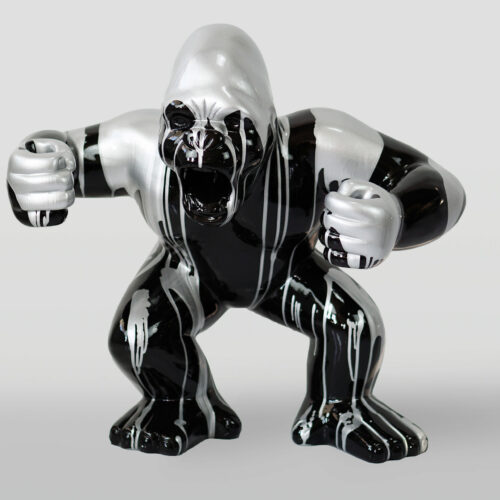 Rzeźba goryla pomalowana na czarno i srebrno o agresywnej postawie.