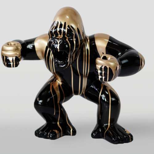 Czarna figurka goryla z złotymi zdobieniami, z zaciśniętymi pięściami.