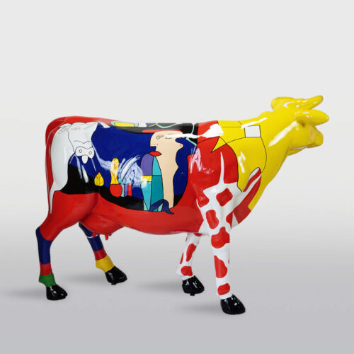 Colorful cow statue with abstract and geometric designs painted in red, blue, yellow, and white.