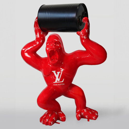 Red gorilla sculpture holding a black barrel, featuring white Louis Vuitton logos on its body.