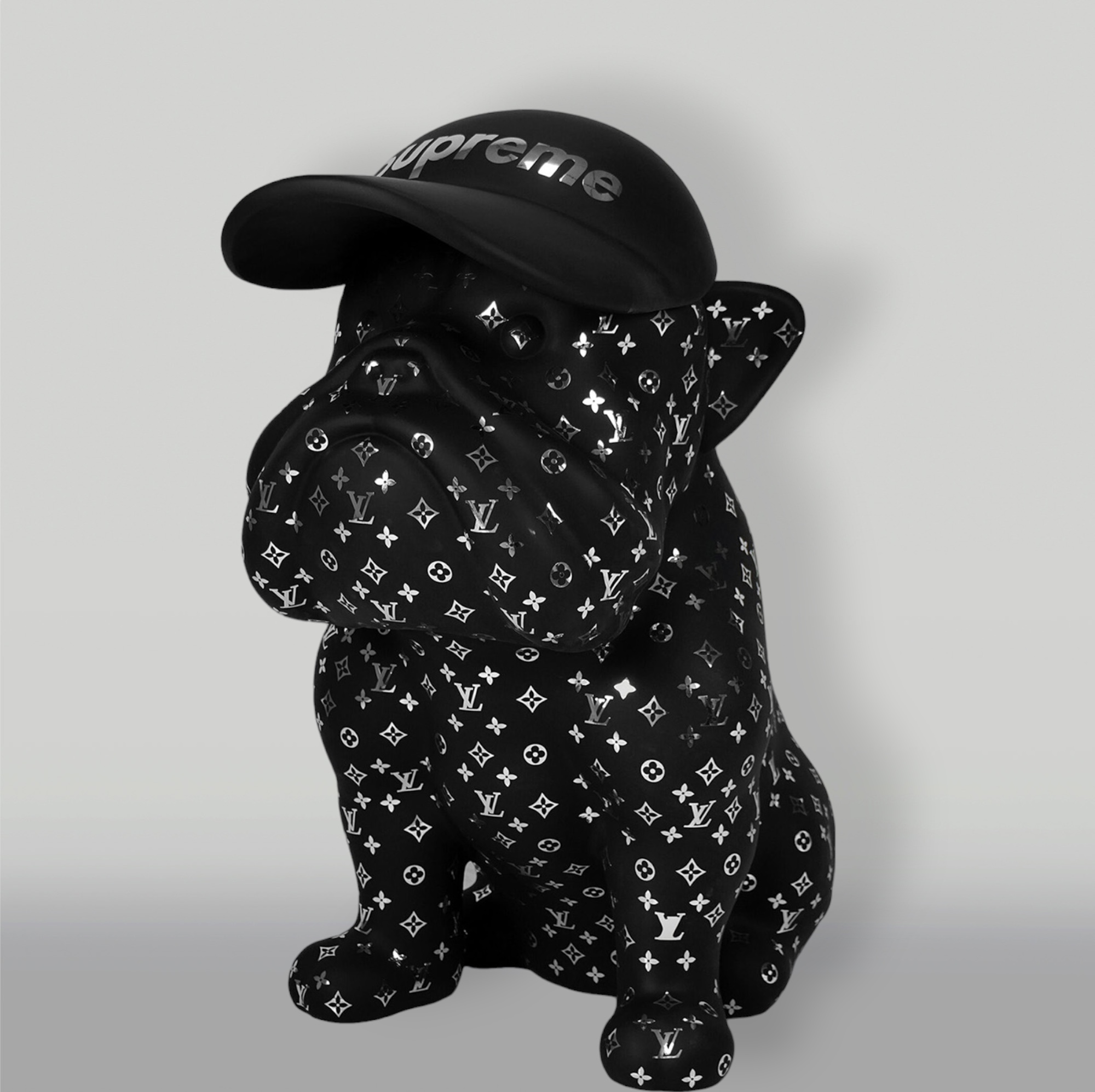 Dog Bulldog with Cap - Matte with Chrome 1 Statue of a black bulldog wearing a black cap with "Supreme" written on it and covered in Louis Vuitton patterns.