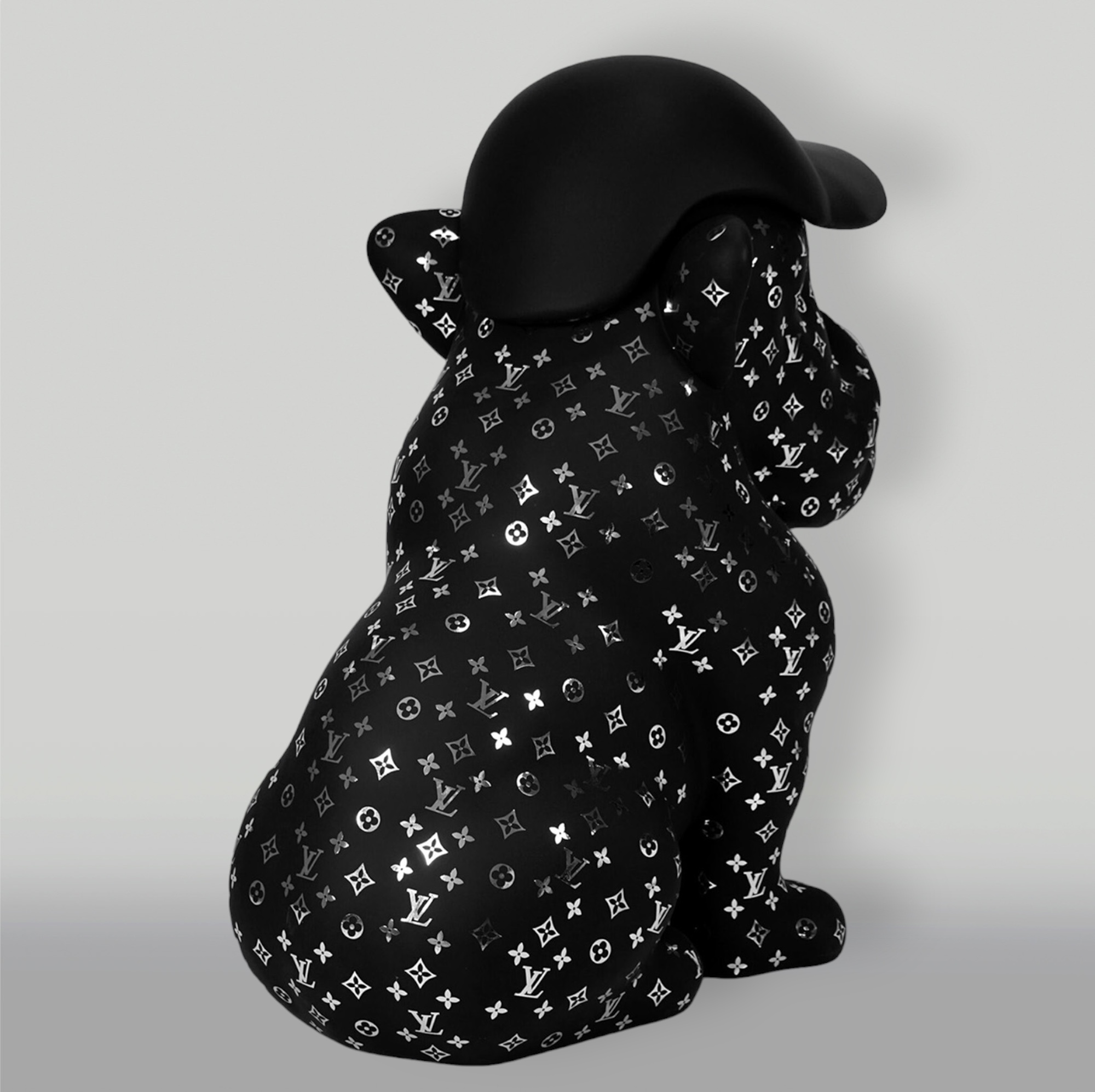 Dog Bulldog with Cap - Matte with Chrome 2 A black statue of a dog wearing a black helmet, covered in a pattern of white and silver Louis Vuitton logos.