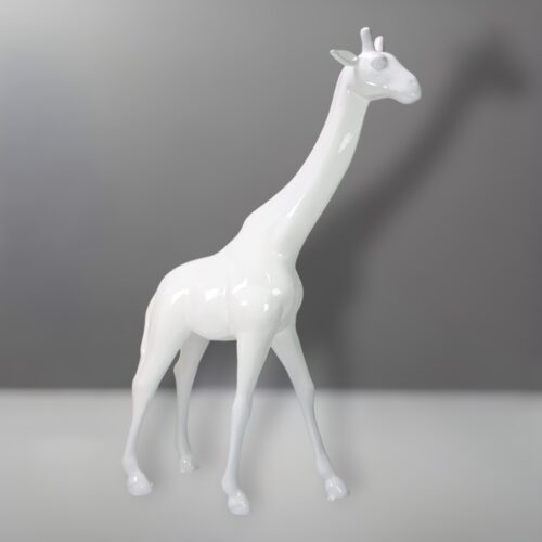 White glossy giraffe statue against a grey background.