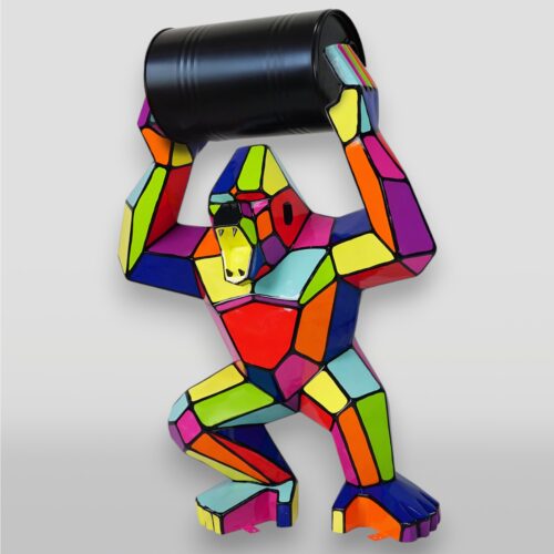 Colorful mosaic gorilla statue holding a black barrel over its head.