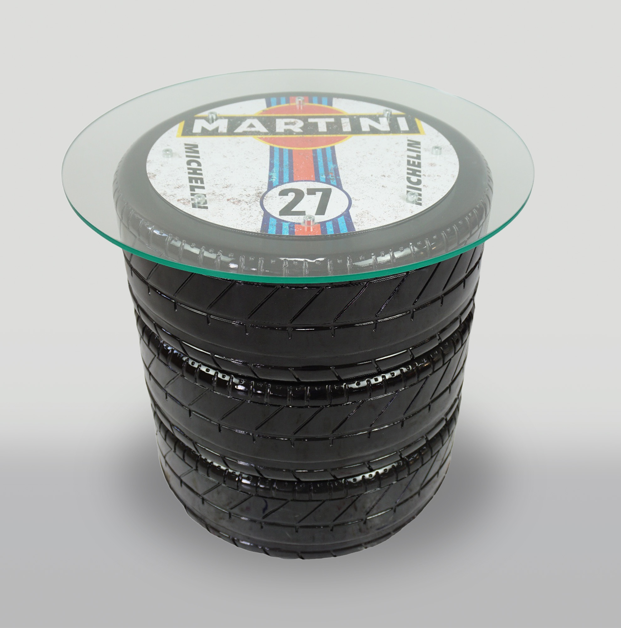 Table with tire with Martini 27 motif 1 A coffee table made from stacked black car tires, topped with a round glass surface displaying a