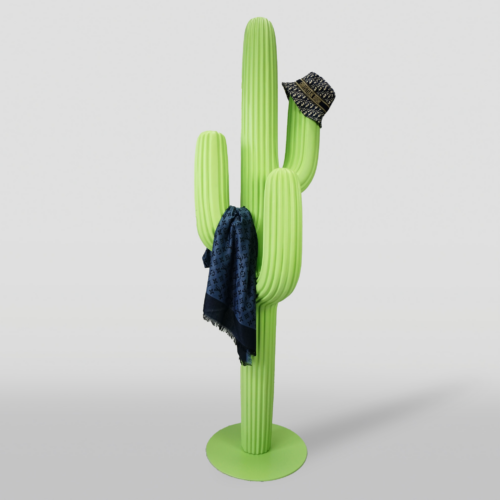 A light green cactus-shaped coat rack with a dark blue scarf draped over one arm and a black patterned hat hanging on another arm, standing on a circular base against a plain background.