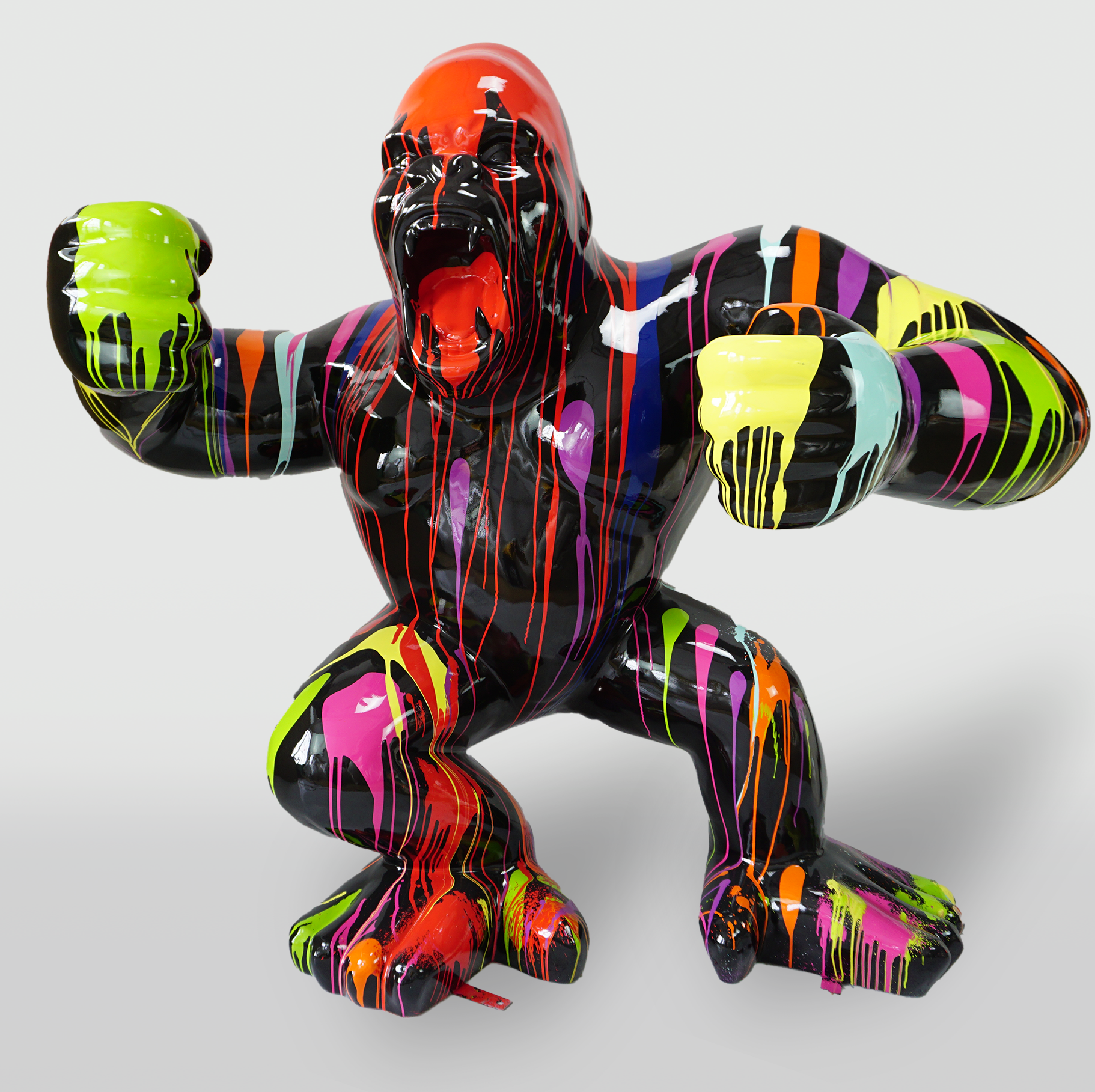 Large gorilla black trash 1 A black gorilla statue with its mouth open, covered in multicolored paint drips, including red, yellow, green, pink, purple, and blue.