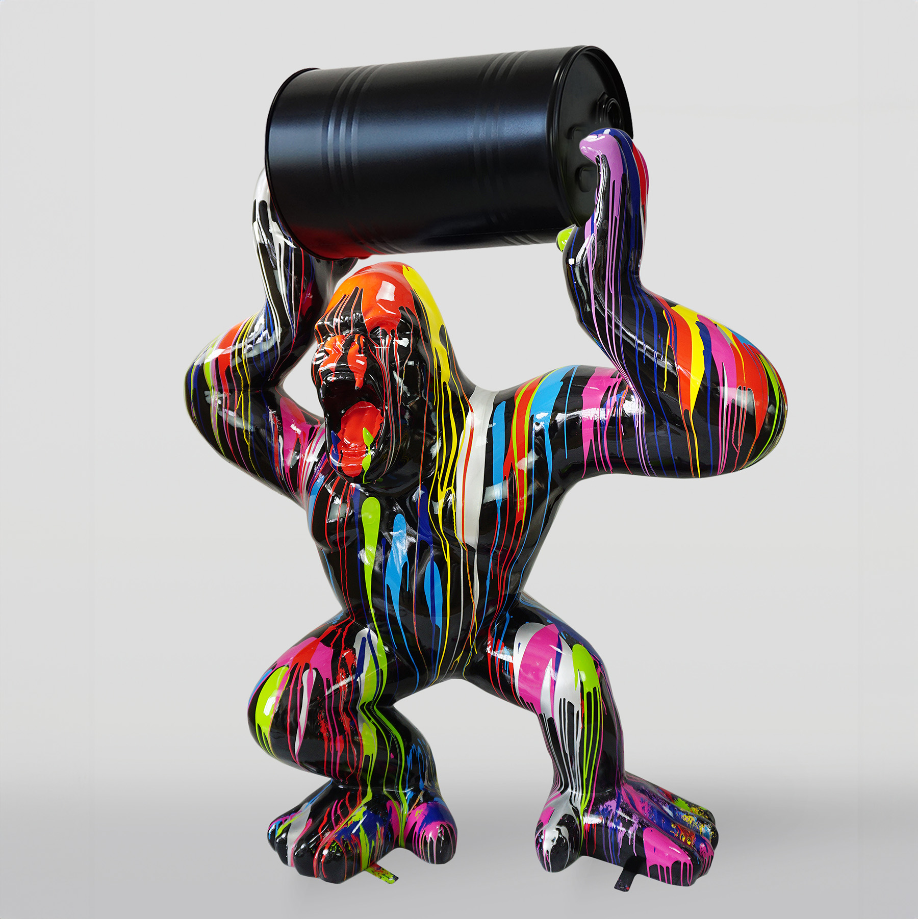 Duży goryl z beczką - Trash 1 Colorful gorilla sculpture holding a black barrel, with multi-colored paint drips on its surface.
