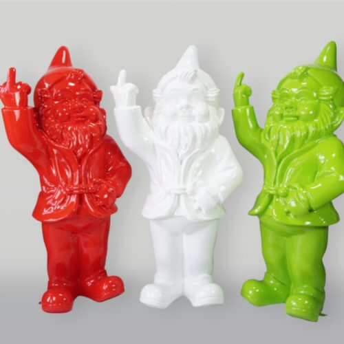 Three colorful gnome statues in red, white, and green with one hand on their waists and the other hand raised, making a rude gesture with the middle finger extended.