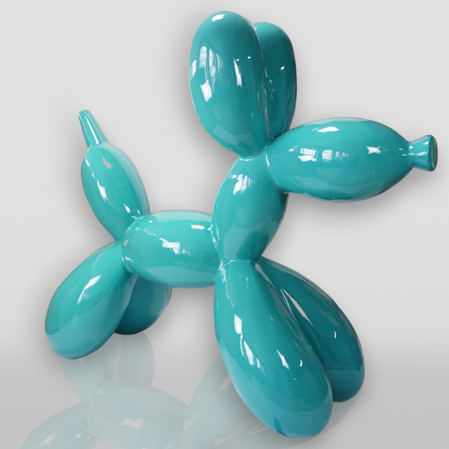 Balloon Dog Large Decorative Figure - Turquoise 1 A shiny, teal-colored sculpture resembling a balloon dog on a reflective surface.