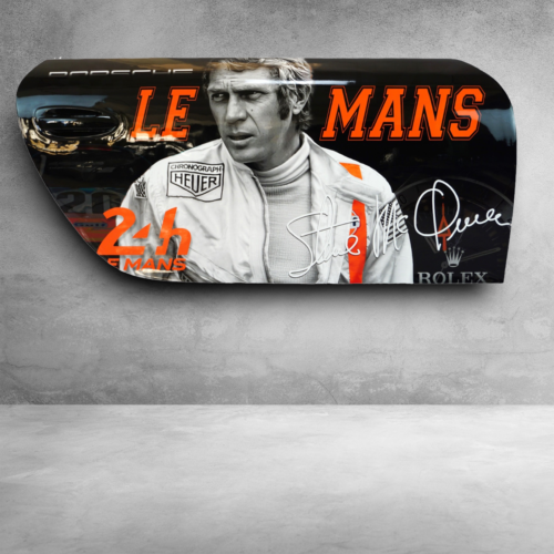 Autographed Le Mans movie poster featuring a driver in racing attire.