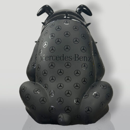 A black bulldog sculpture with the Mercedes-Benz logo and text, adorned with numerous smaller Mercedes-Benz logos.