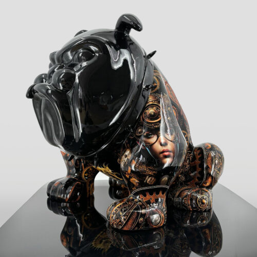 A glossy black statue of a bulldog with detailed steampunk designs and a portrait of a woman's face on its side, placed on a reflective surface.