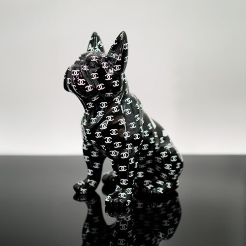 A black statue of a sitting French Bulldog covered in a pattern of white interlocking 