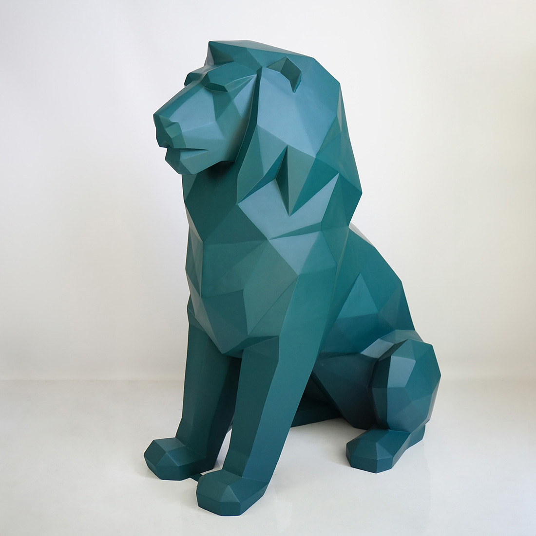 Monochromatic Geometric Lion Figure 1 Green geometric lion statue on a white background.