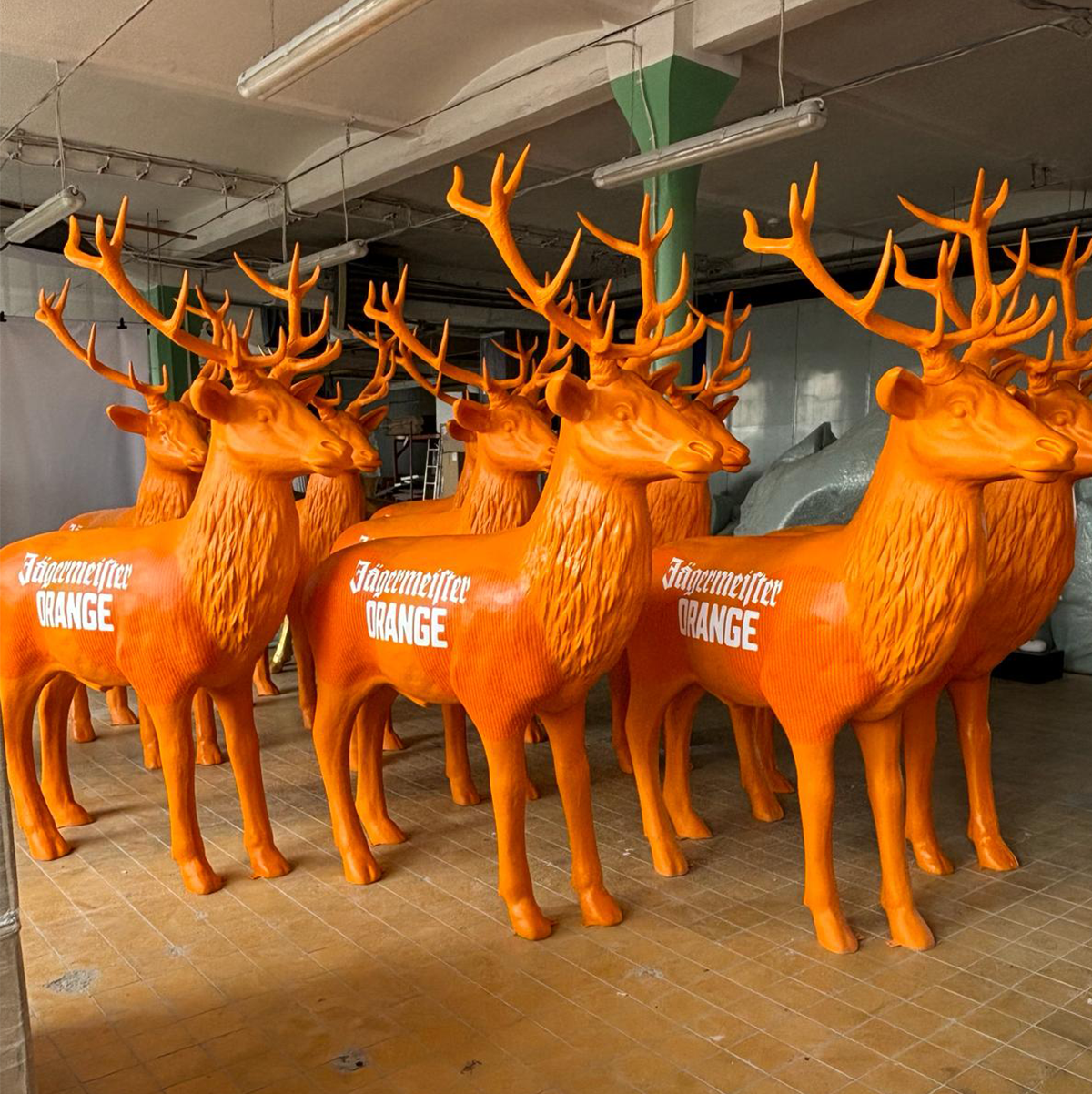 Several orange statues of deer with large antlers, displaying the text 