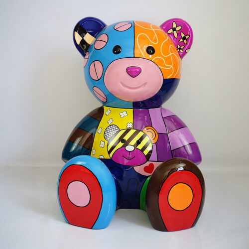 Colorful, patchwork-style teddy bear sculpture with polka dots, stripes, and various patterns.