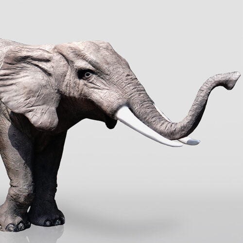 Statue of a woolly mammoth with tusks raised.