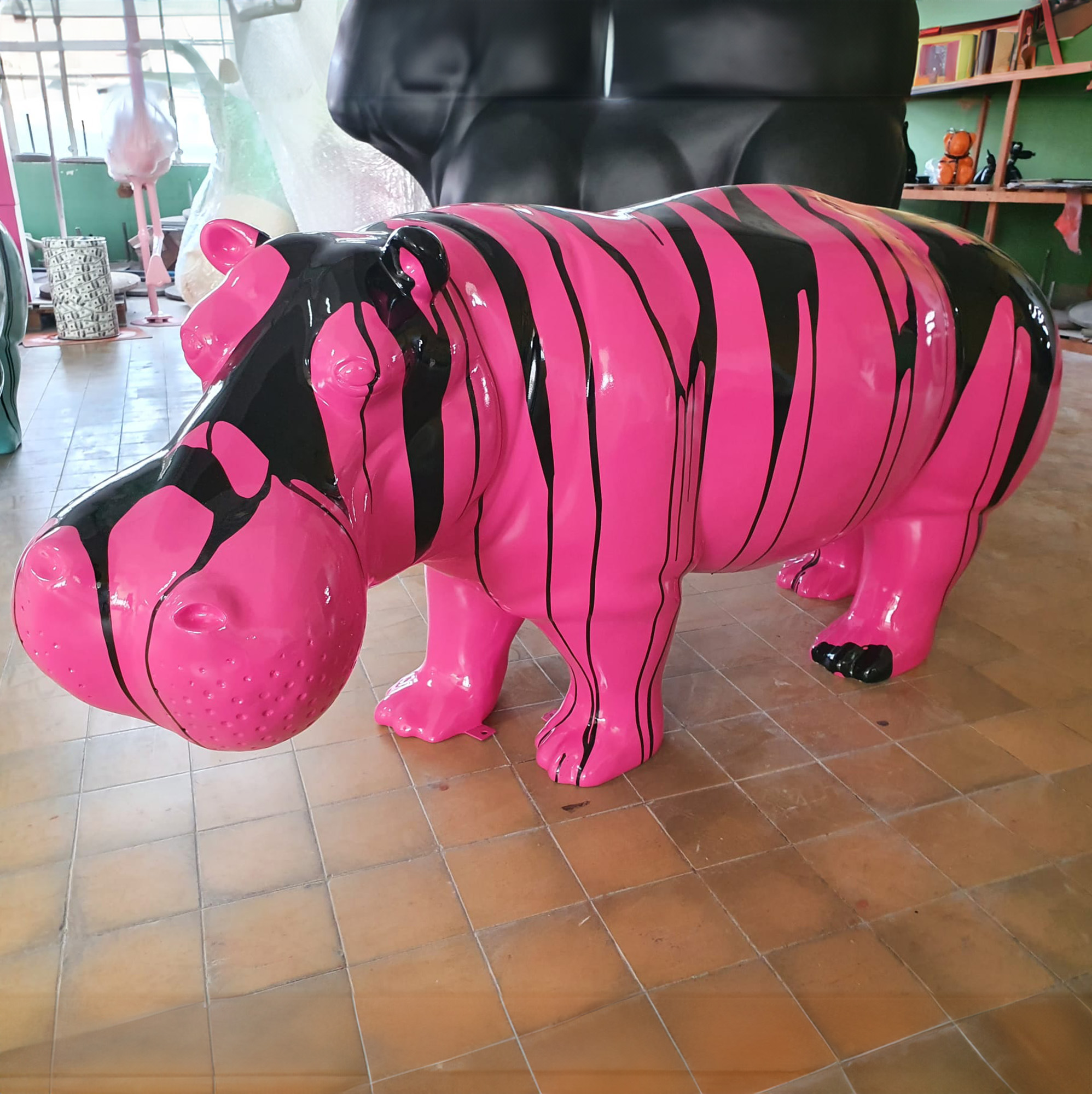 3D Figure Made of Laminate - Life-Size Hippopotamus - Trash 2 Pink and black hippo sculpture in an art studio.