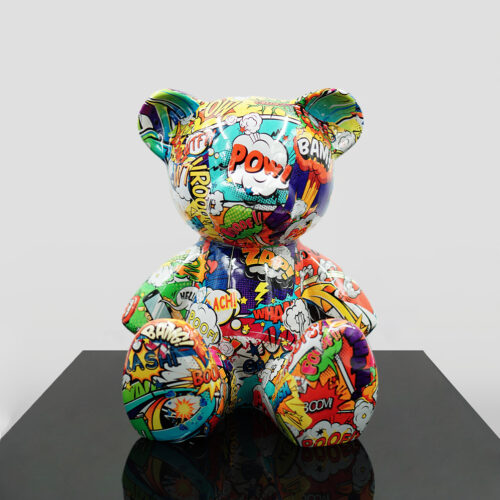 A multicolored teddy bear statue covered in comic book-style illustrations, featuring onomatopoeic words like