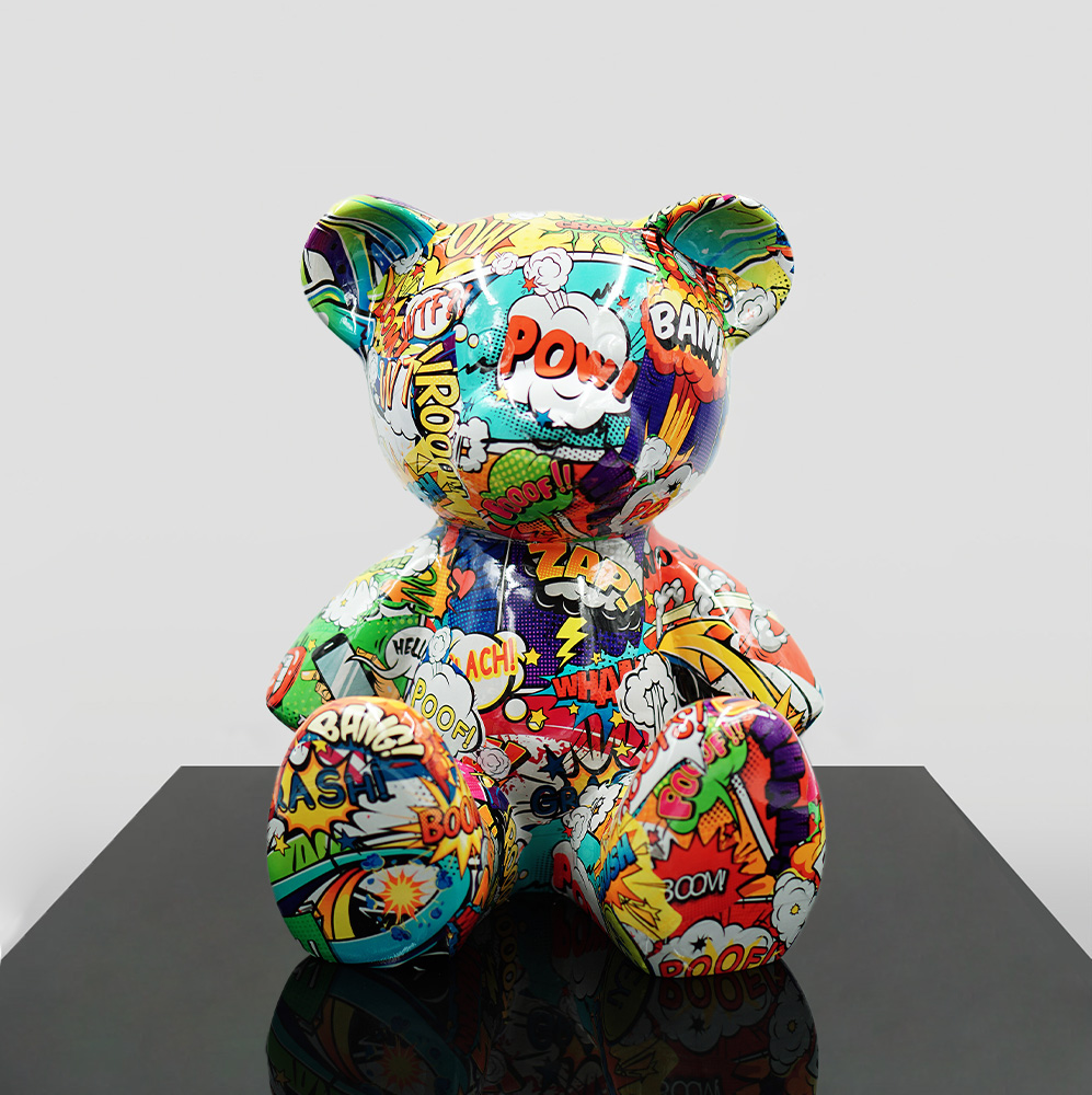 A multicolored teddy bear statue covered in comic book-style illustrations, featuring onomatopoeic words like 