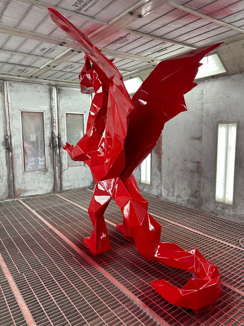 Low Poly Dragons at the Radisson Hotel 11 Czerwona, geometryczna rzeźba smoka w warsztacie.
