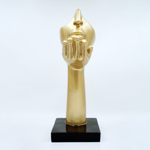 Red sculpture of a hand with an abstract face, mounted on a black square base.