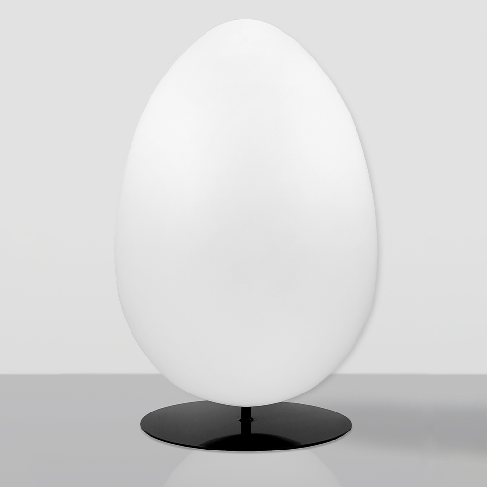 Decorative Figure White Easter Egg XXL - Round Base 1 Smooth, large white egg-shaped object mounted on a flat, round black base, placed on a reflective grey surface against a light grey background.