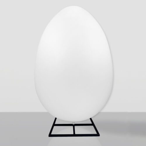 Large smooth white egg-shaped object mounted on a simple black metal stand against a light gray background