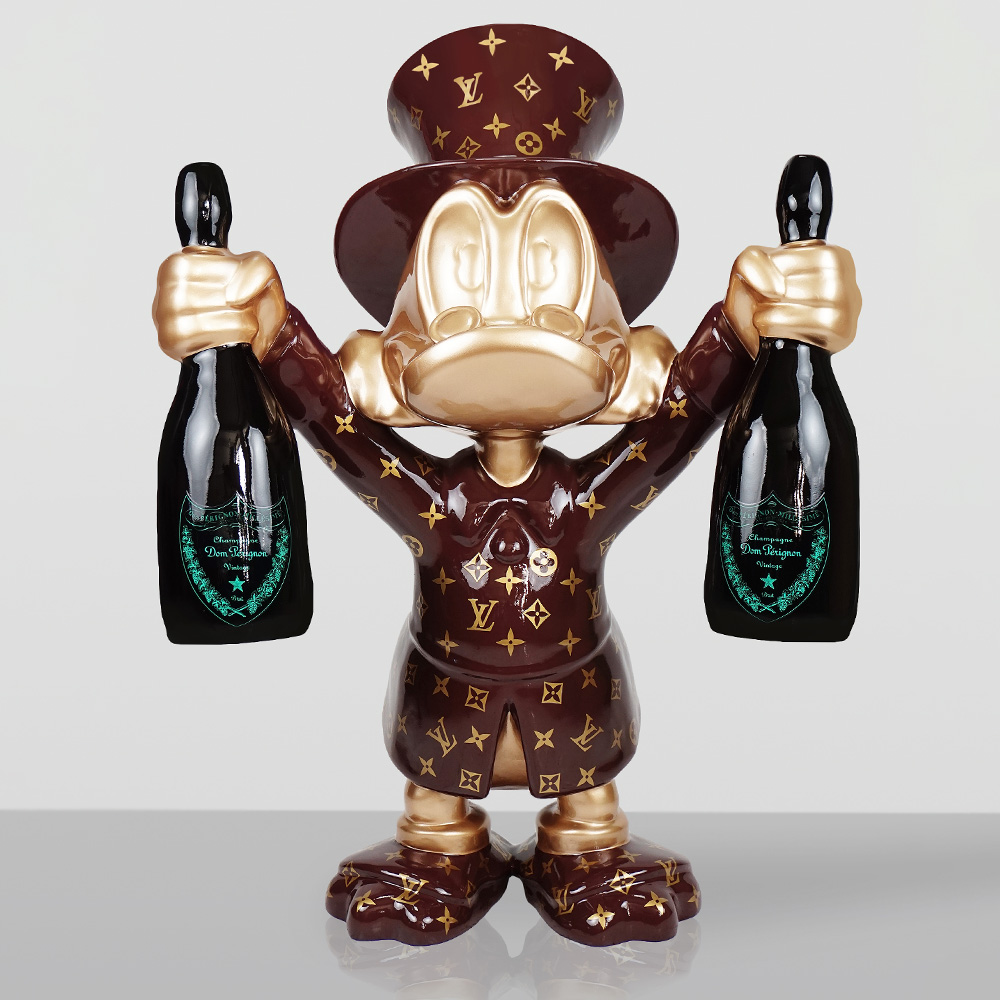 Decorative Figurine – Small Scrooge McDuck 2 Stylized figurine of a character resembling Donald Duck wearing a brown top hat and coat decorated with a gold Louis Vuitton monogram pattern, holding a bottle of Dom Pérignon champagne in each hand against a plain light background.
