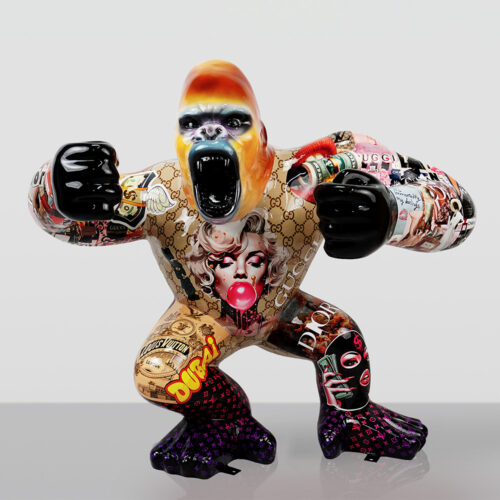 Colorful gorilla sculpture with fists raised, decorated with various luxury brand logos, pop art images including Marilyn Monroe blowing bubblegum, and graffiti-style text on a plain background.
