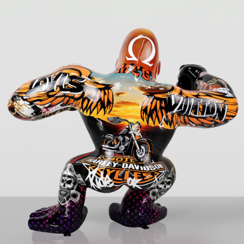 Sculpture of a crouching figure with a colorful, detailed paint design featuring motorcycle imagery, skulls, wings, and various text including Harley-Davidson and Louis Vuitton logos, against a plain light gray background.