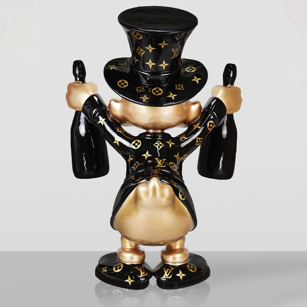 Decorative Figurine – Large Scrooge McDuck 3 Back view of a shiny, gold and black figurine wearing a top hat and suit adorned with Louis Vuitton patterns, holding two large black bottles, standing on a reflective surface with a plain background.