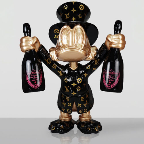 Sculpture of a character resembling Donald Duck dressed in a black Louis Vuitton patterned outfit and top hat, with gold face and hands, holding a bottle of Dom Pérignon Rosé champagne in each hand against a plain light gray background.