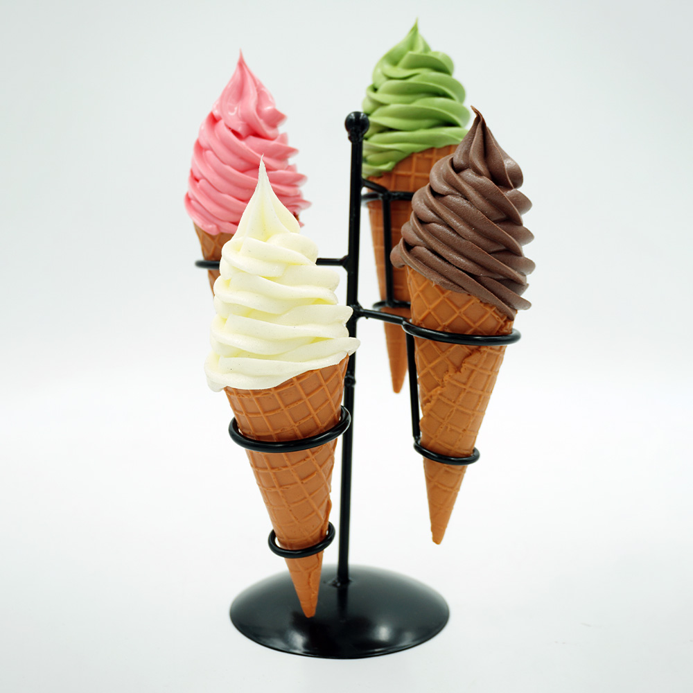 Decorative Ice Cream Basket – Motif III 5 Four ice cream cones with swirled soft serve in pink, green, white, and chocolate colors, held upright by a black metal stand against a white background
