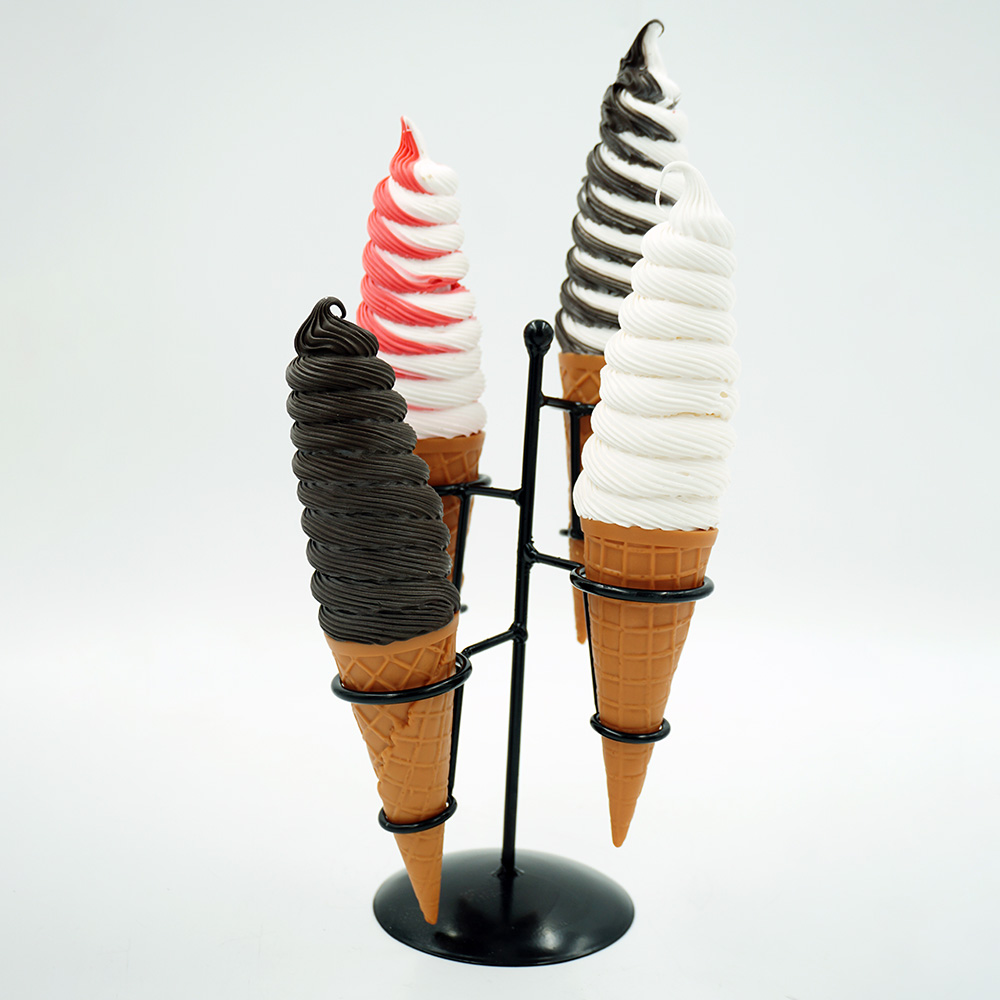Decorative Ice Cream Basket – Motif III 1 Four soft-serve ice cream cones in a black metal stand, featuring one dark chocolate, one white with red swirl, one black and white swirl, and one white cone against a plain white background.