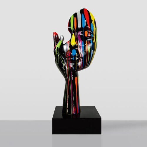 Abstract sculpture of a human face with a hand resting on the cheek, painted with vertical drips of bright colors including red, yellow, blue, green, and orange on a glossy black surface, mounted on a black square base against a plain light gray background.