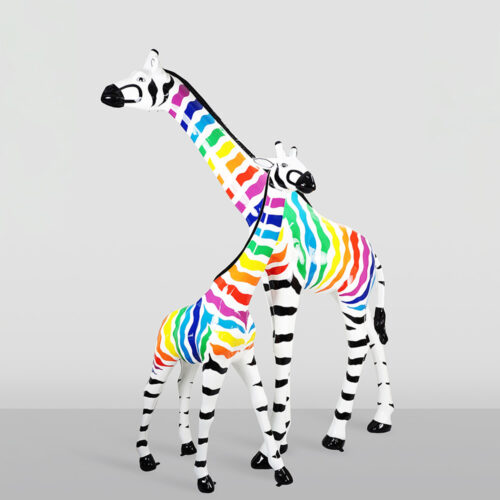 Two giraffe sculptures with black and white stripes on their legs and heads, and rainbow-colored stripes on their necks and bodies, standing against a plain light gray background.
