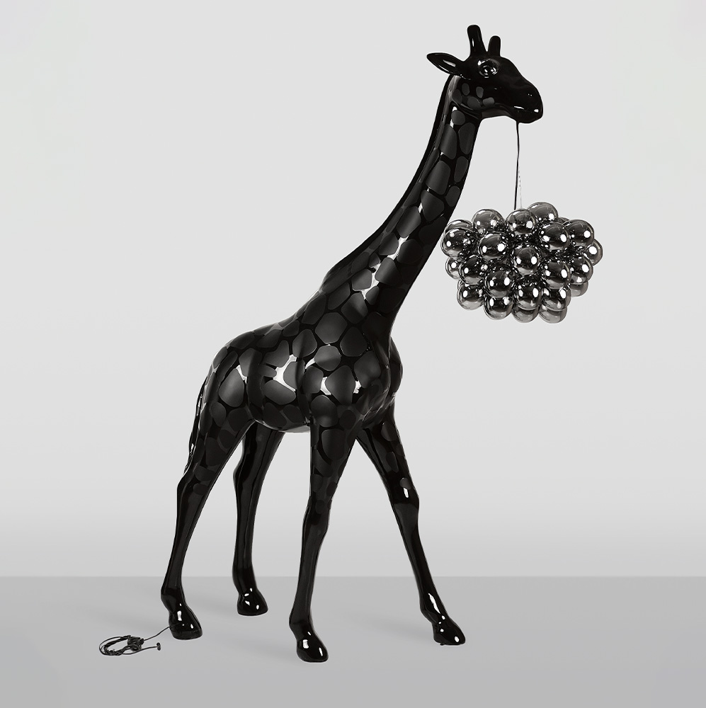 Large Giraffe 230cm Lamp – Black Version with Spots 1 Glossy black giraffe sculpture with a cluster of reflective silver spheres hanging from its mouth against a plain light gray background.