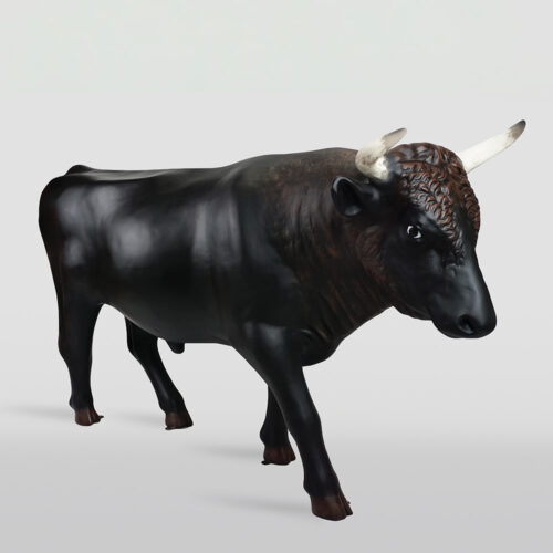 Realistic black bison statue with white-tipped horns standing against a plain light gray background.