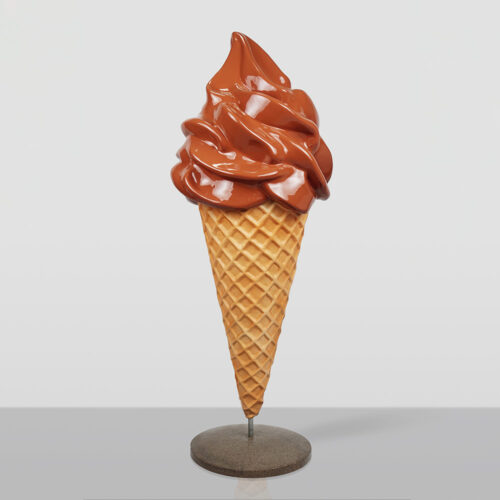 Life-size display of a chocolate soft serve ice cream cone with a waffle cone base on a stand against a plain light background