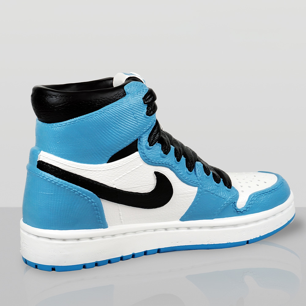 Decorative Figurine – Giant Nike Air Jordan I Shoe 2 Side view of a high-top sneaker with white, light blue, black, and white sole, featuring black laces and a black Nike swoosh logo on the side.