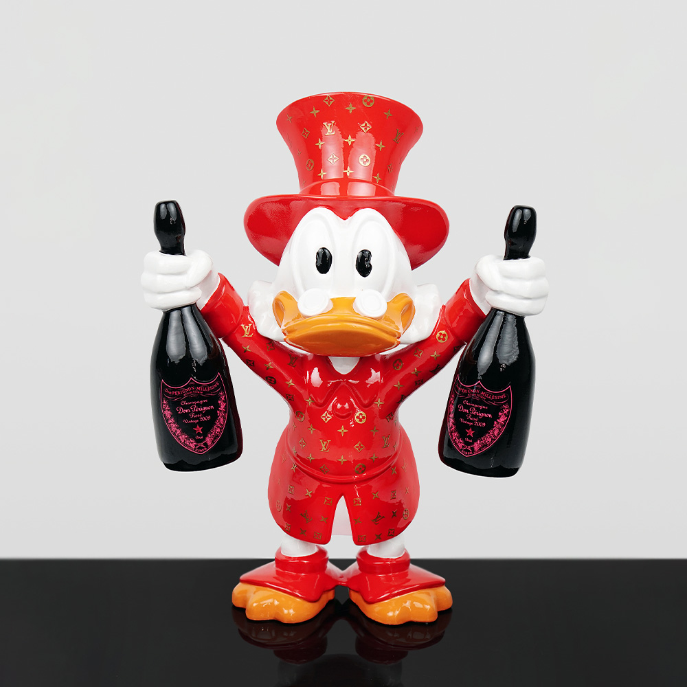 Decorative Figure – Mini Scrooge McDuck 4 Figurine of a duck character wearing a red Louis Vuitton patterned suit and top hat, holding a bottle of Dom Pérignon champagne in each hand, standing on a reflective black surface against a plain light background.