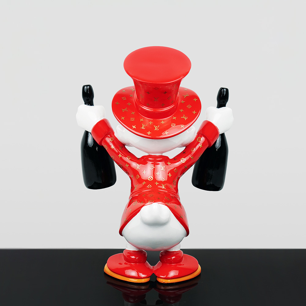 Decorative Figure – Mini Scrooge McDuck 5 Back view of a glossy white duck figurine dressed in a red top hat and jacket with gold Louis Vuitton monogram pattern, holding a black bottle in each hand, standing on a reflective black surface against a neutral gray background.
