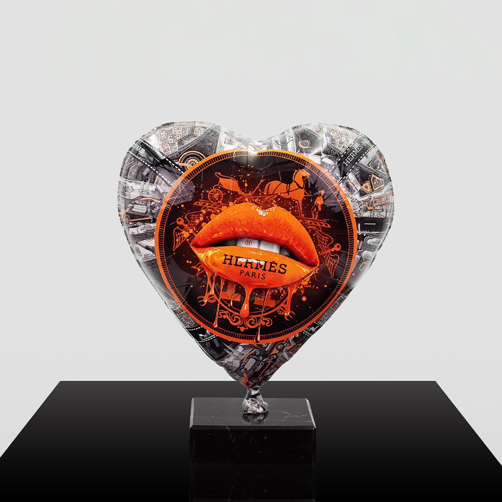 Decorative Heart-Shaped Balloon Figurine 11 Heart-shaped balloon sculpture with a silver and black pattern featuring a central orange dripping lip design and the text