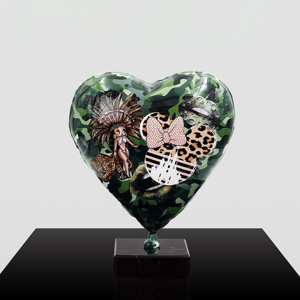 Decorative Heart-Shaped Balloon Figurine 10 Heart-shaped camouflage balloon with various stickers including a pin-up girl with a feathered headdress, leopard print Mickey Mouse head with a pink bow, and black lips with water droplets, mounted on a black pedestal against a plain background.