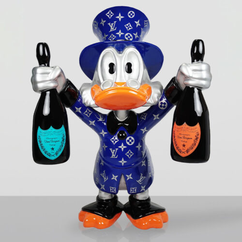 Figurine of a duck wearing a blue Louis Vuitton-patterned coat and top hat, holding two bottles of Dom Pérignon champagne with one bottle in each hand against a neutral background.