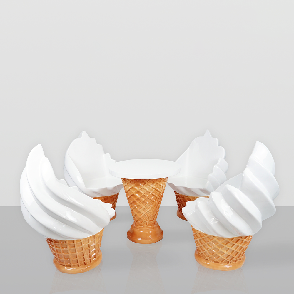 Ice cream shop furniture set – waffle cone table + ice cream chairs 1 A whimsical furniture set consisting of a table and four chairs designed to look like ice cream cones with white swirl ice cream tops, on a reflective surface against a plain light gray background.